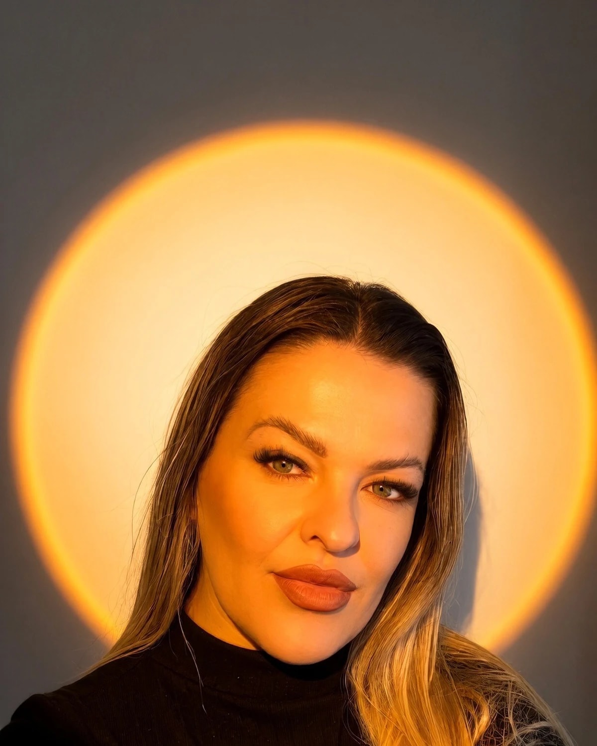 Daniela Silva em retrato com luz dourada ao fundo