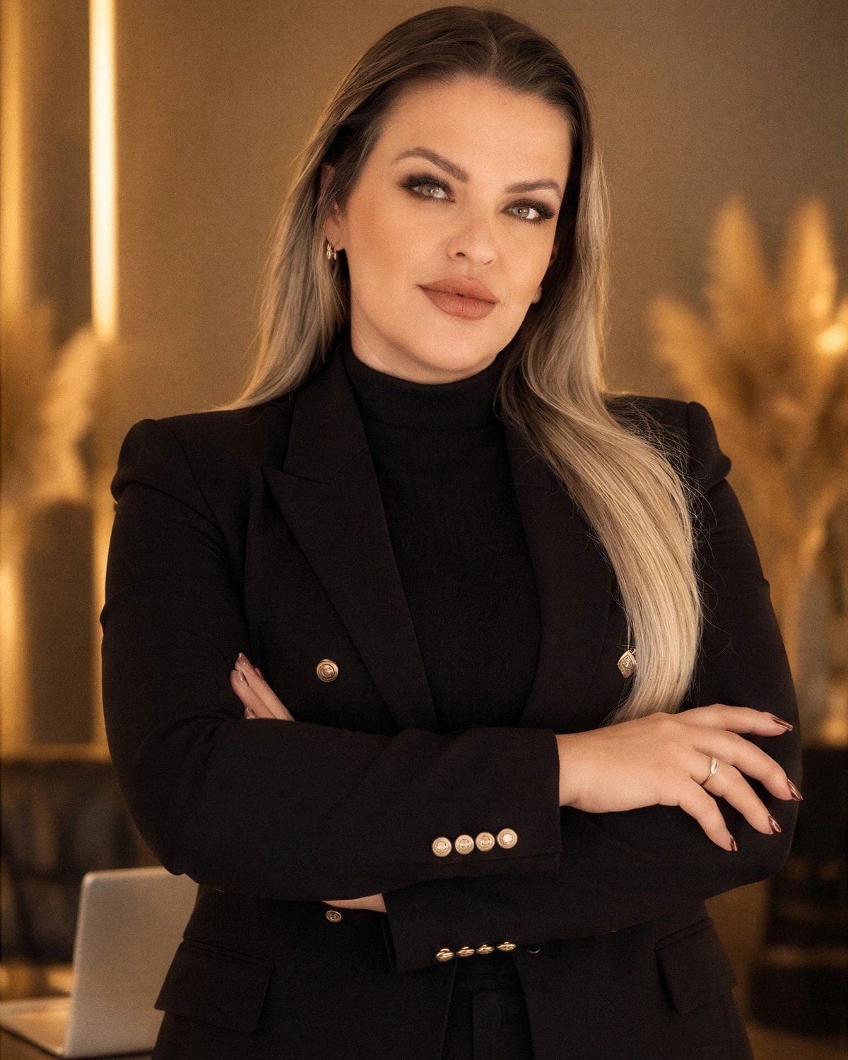 Daniela Silva de braços cruzados, em estúdio com luz quente